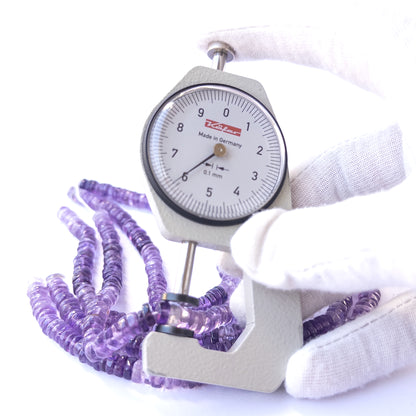 A dial gauge measures the Amethyst smooth wheel 6–6.3mm gemstone.