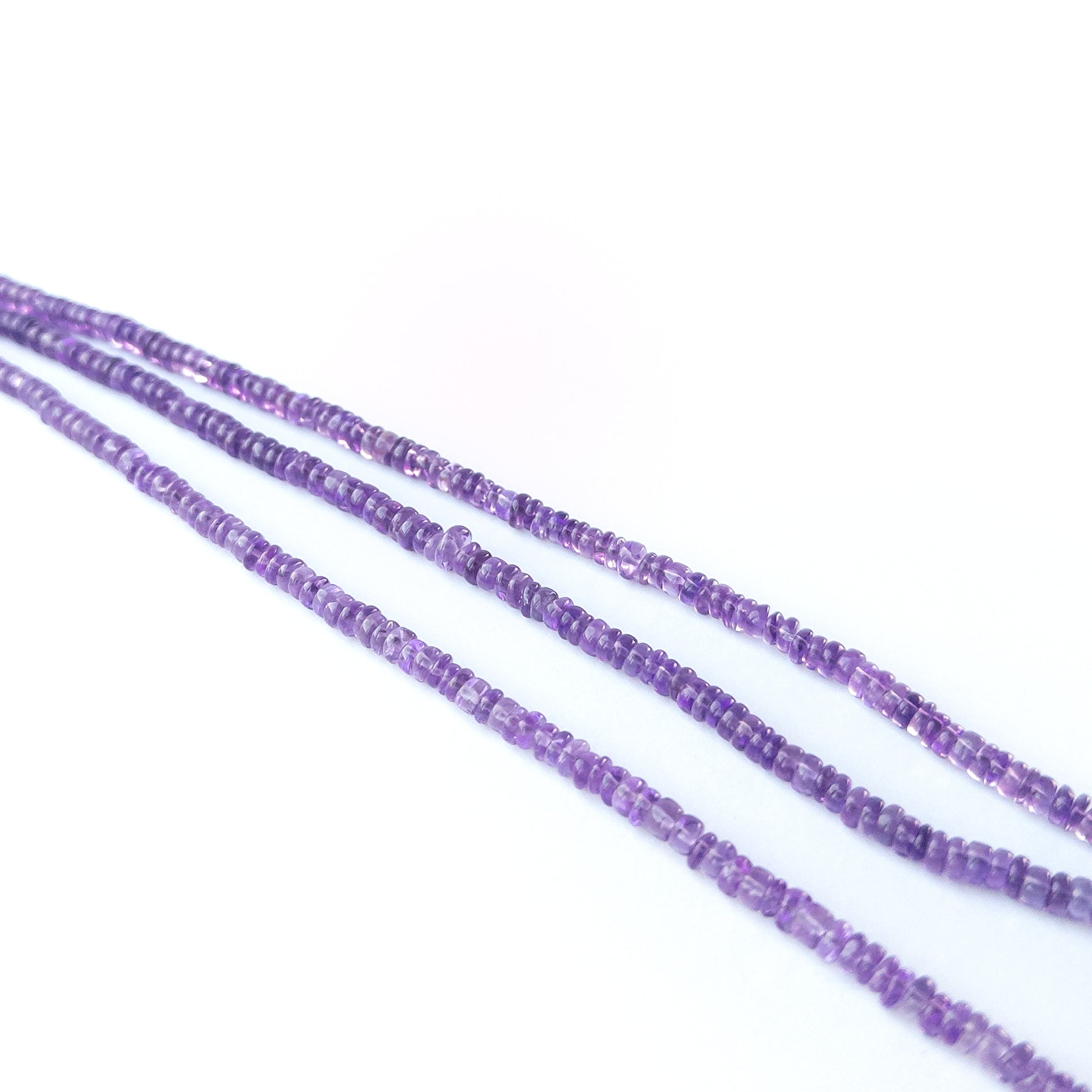 Close‑up of genuine Amethyst smooth wheel beads showing polished shine and natural lavender tones.