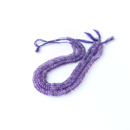 Handmade jewellery components featuring smooth Amethyst wheel beads in a neatly arranged strand.