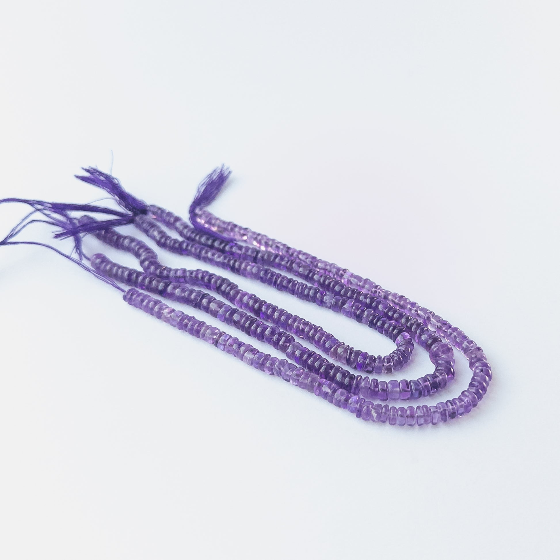 Amethyst wheel beads showcasing natural shine and elegant rounded shape for gemstone bead creators.