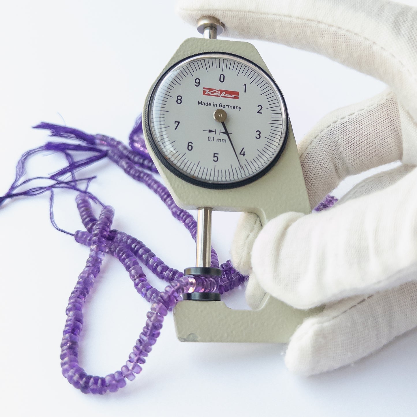 A dial gauge measures the Amethyst smooth wheel 4–5mm gemstone.