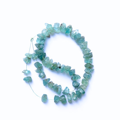 Close‑up of blue Apatite drilled rough beads with rugged surfaces and bright gemstone colour.