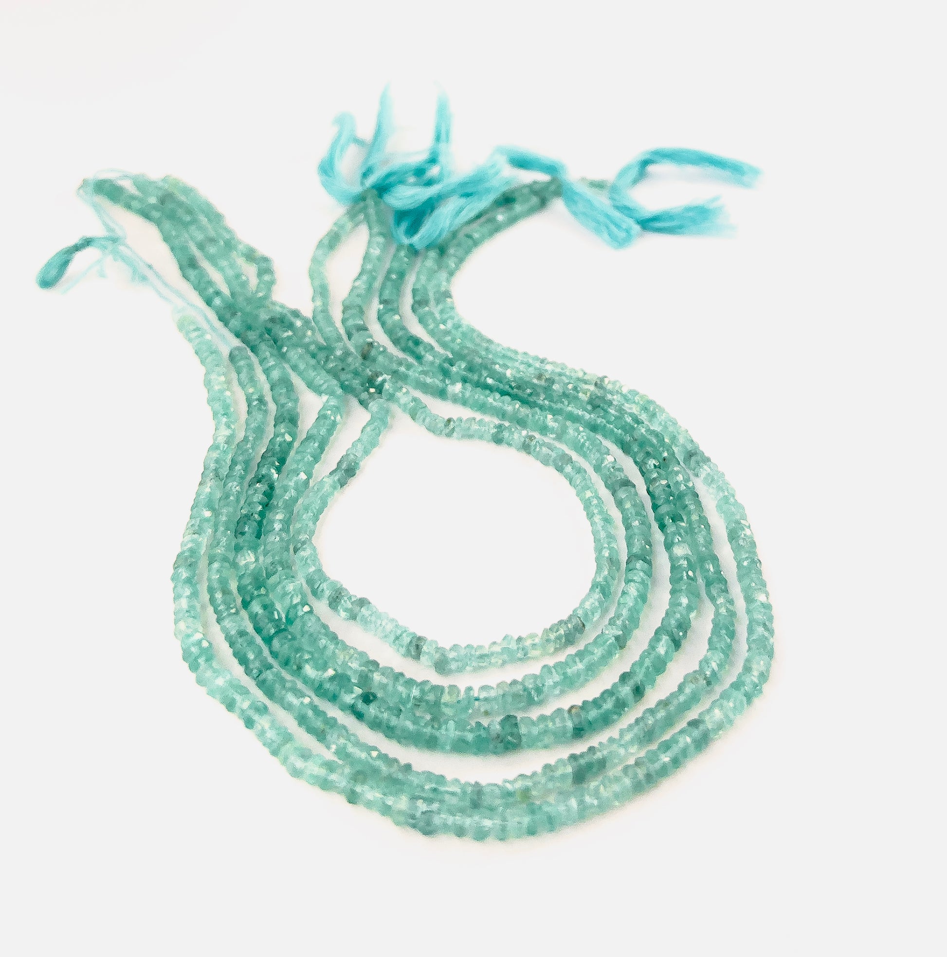 Apatite faceted rondelle beads sized 3.5–3.9mm and 4–4.5mm arranged in a 33cm strand, showing vivid aqua‑blue colour and bright sparkle.