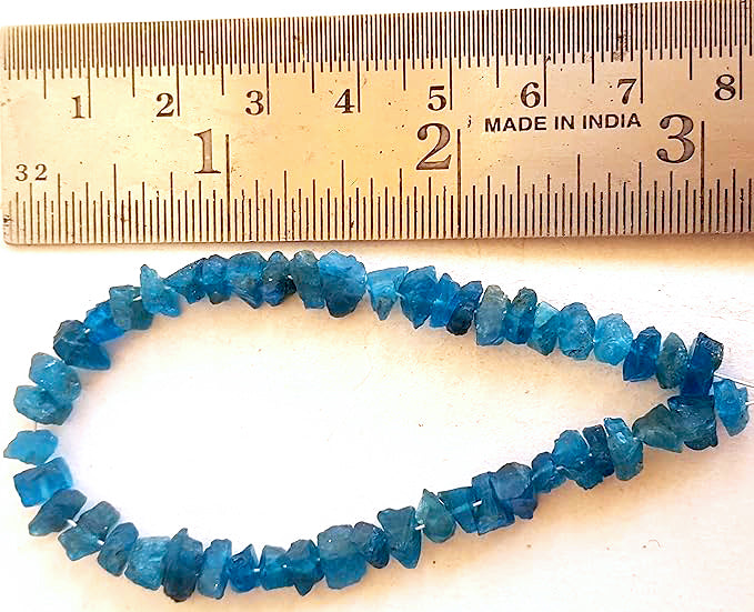 A ruler measures the Apatite rough 5-7mm gemstone.