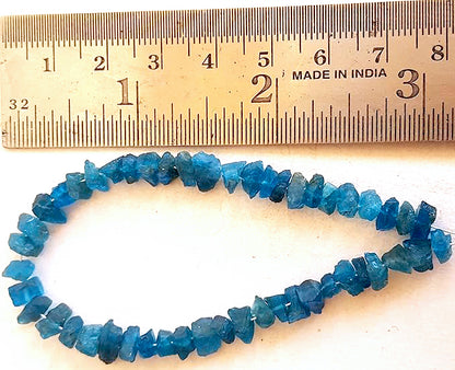 A ruler measures the Apatite rough 5-7mm gemstone.