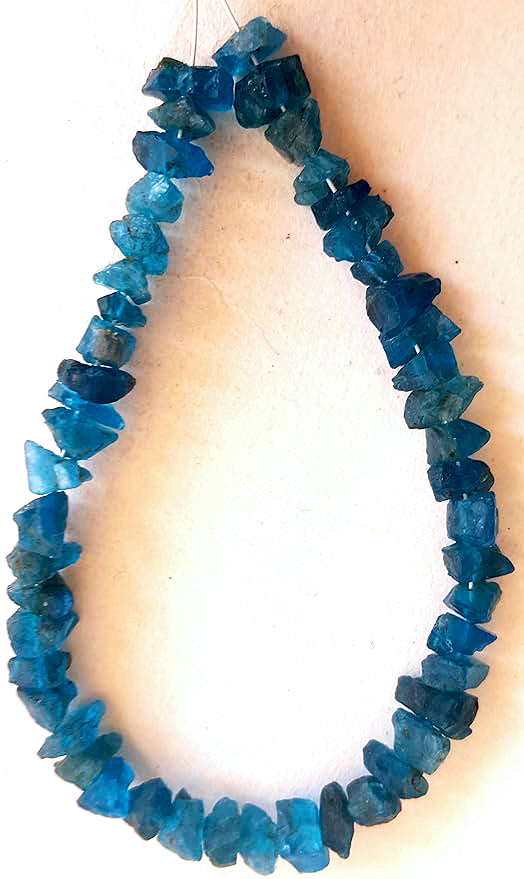 Apatite beads arranged in a loose strand, highlighting their raw cut and natural brilliance.