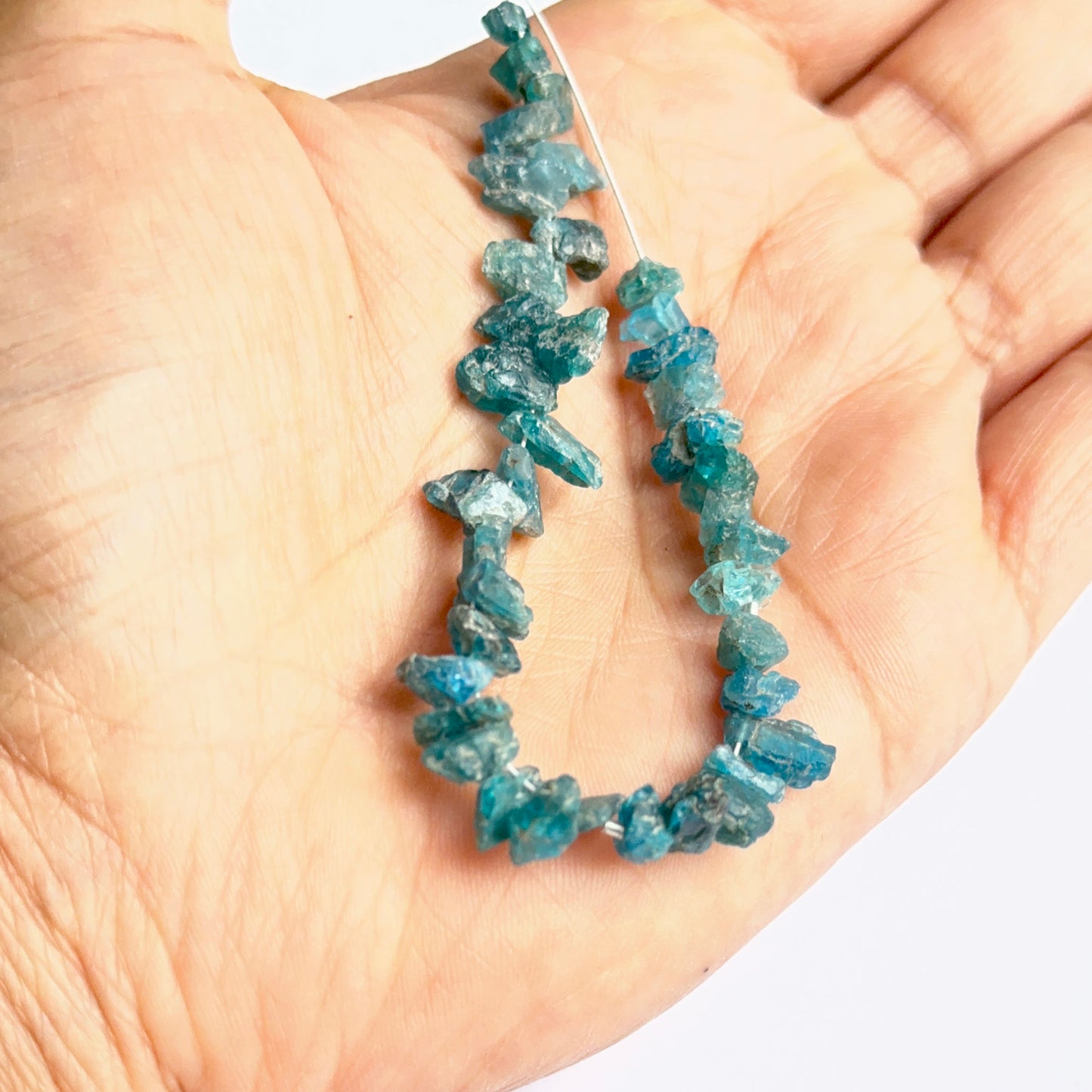 Close‑up of apatite rough stone beads highlighting their organic shape and vibrant colour for DIY jewellery.