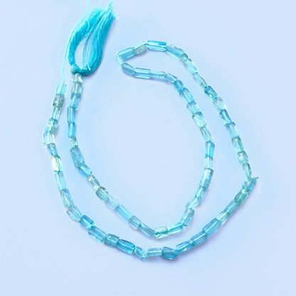 Apatite smooth rectangle beads aligned on a strand highlighting clarity, colour and consistent 3mm sizing.