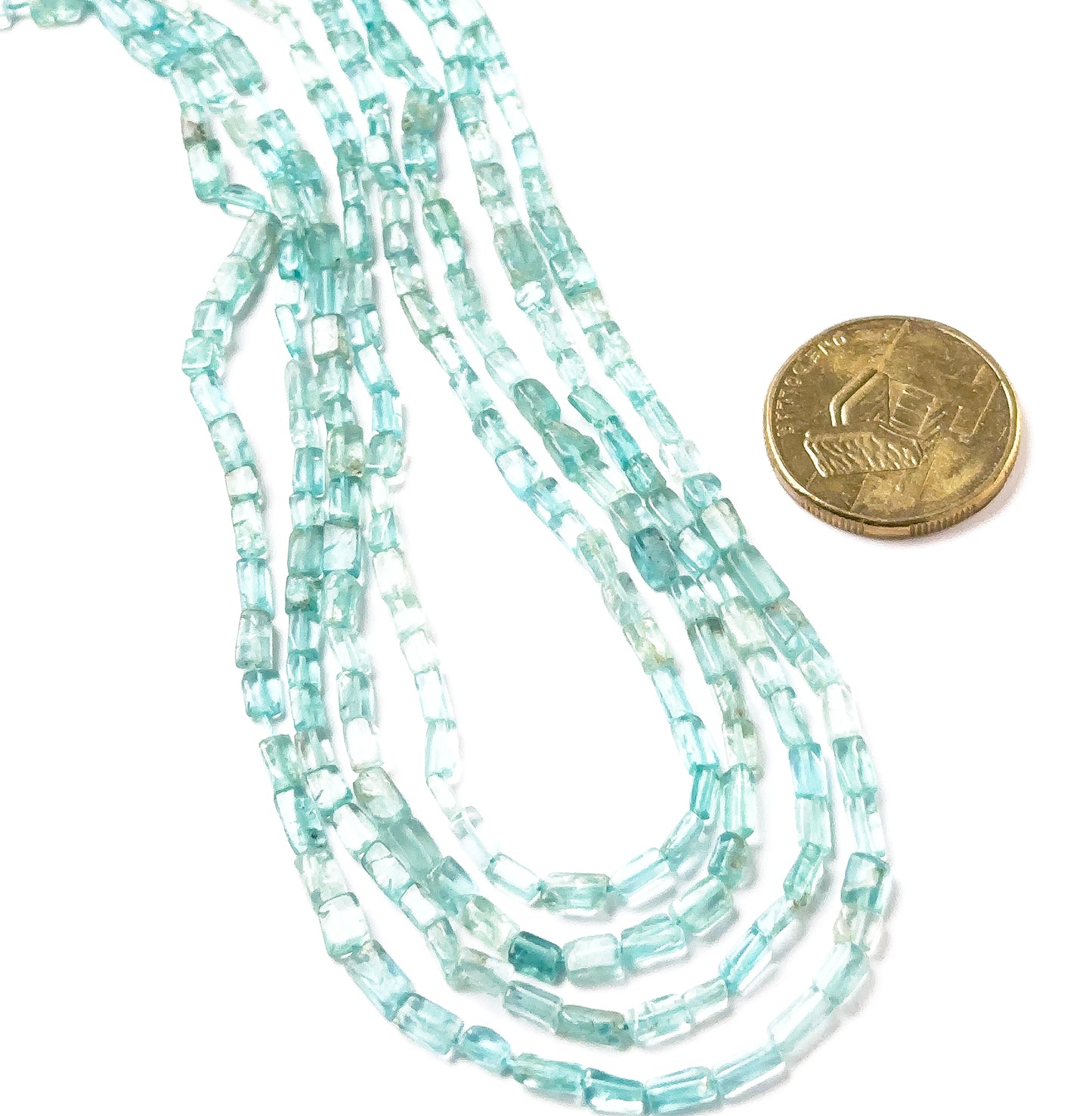 A coin is placed near Apatite smooth rectangle heishi beads to show the 3.3–3.5mm size range.