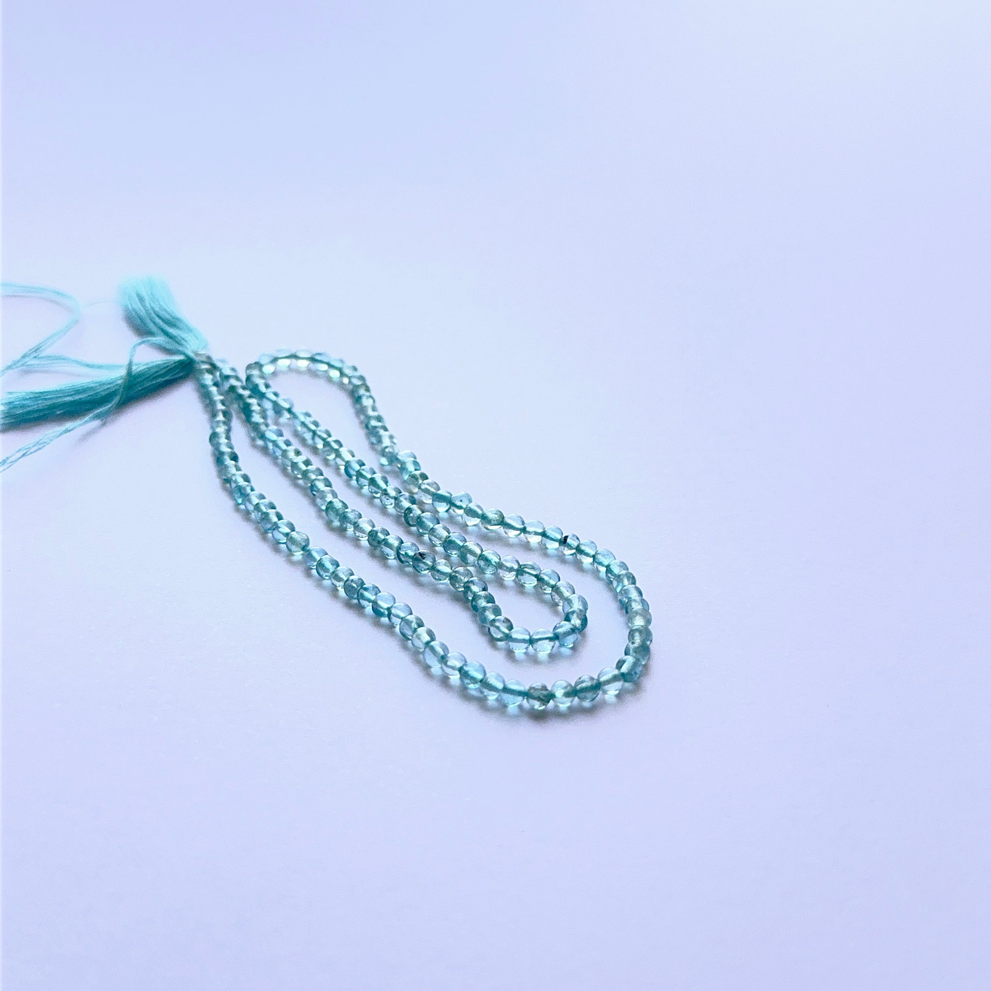 Detailed view of premium Apatite stone beads showing uniform 2.9mm shape, soft glow and vibrant blue colour.