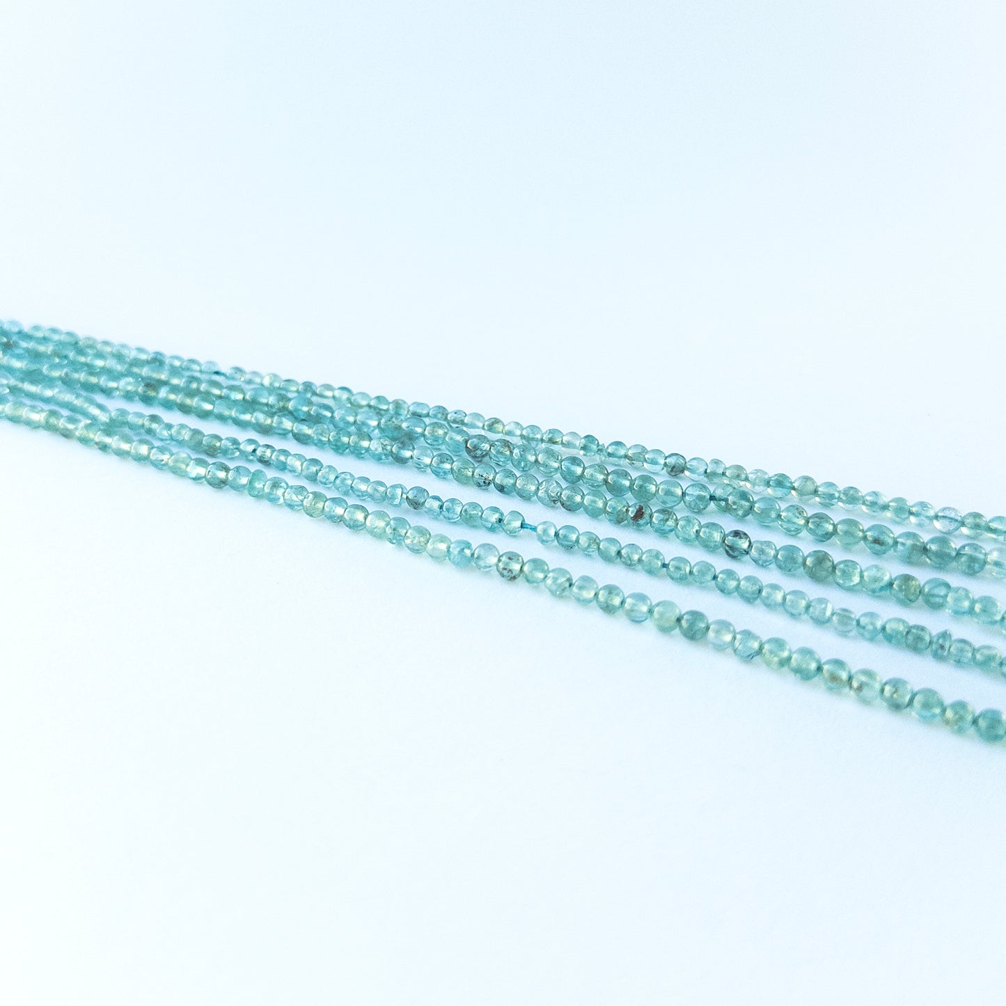 Detailed view of 3.4–3.6mm apatite round beads with smooth polish and vibrant colour for handmade jewellery components.