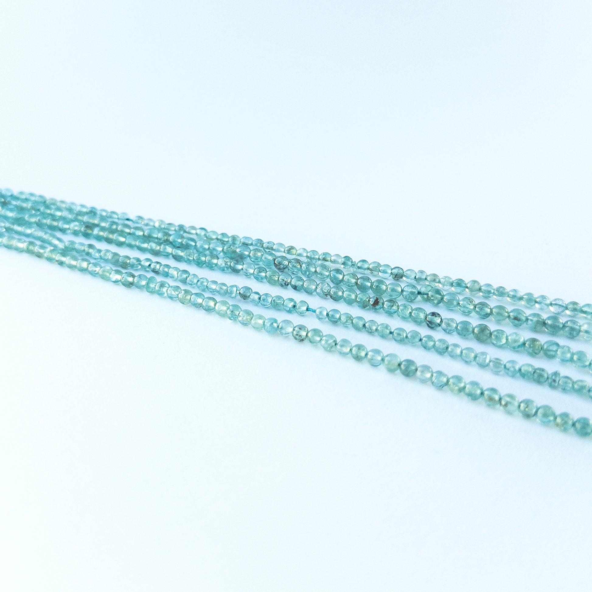 Detailed view of 3.4–3.6mm apatite round beads with smooth polish and vibrant colour for handmade jewellery components.