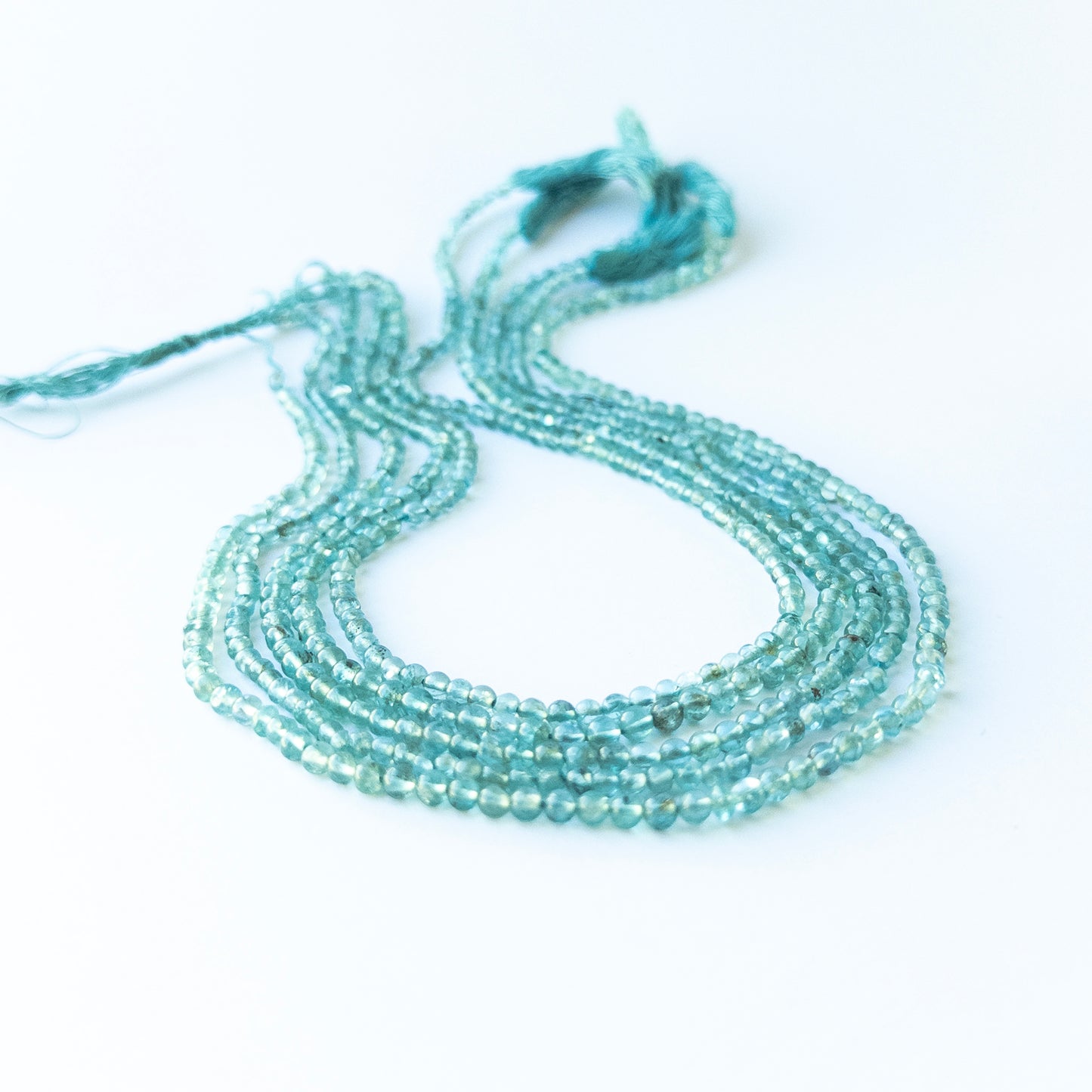 Close‑up of genuine apatite smooth round gemstone beads with natural shine for DIY jewellery making.