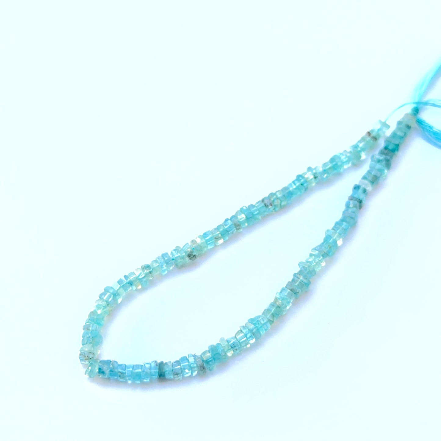 Apatite smooth square Heishi beads aligned on a strand highlighting colour depth, uniformity and high‑quality craftsmanship.