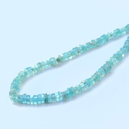 Apatite smooth square Heishi natural gemstone beads in bright blue tones arranged on a 20cm strand for handmade jewellery components.
