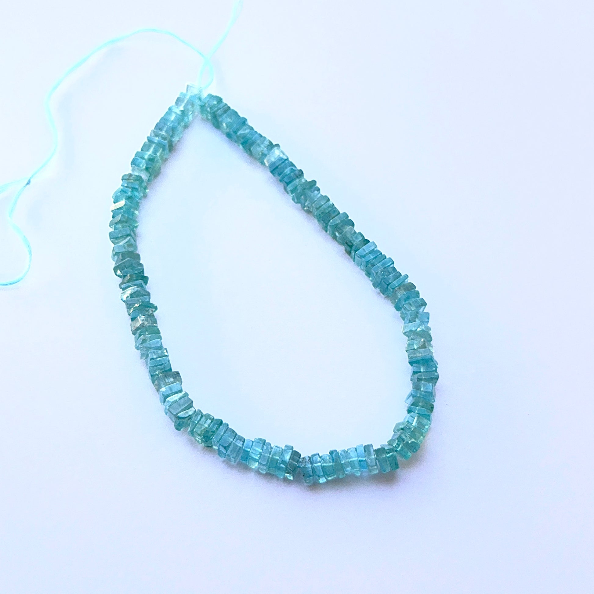 Apatite smooth square Heishi beads aligned on a strand highlighting colour depth, uniformity and high‑quality craftsmanship.