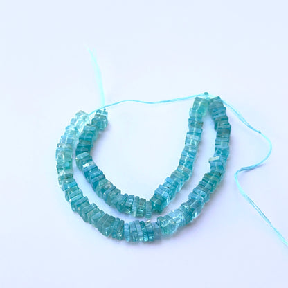 Apatite smooth square Heishi natural gemstone beads in vivid blue tones arranged on a 21cm strand for handmade jewellery components.