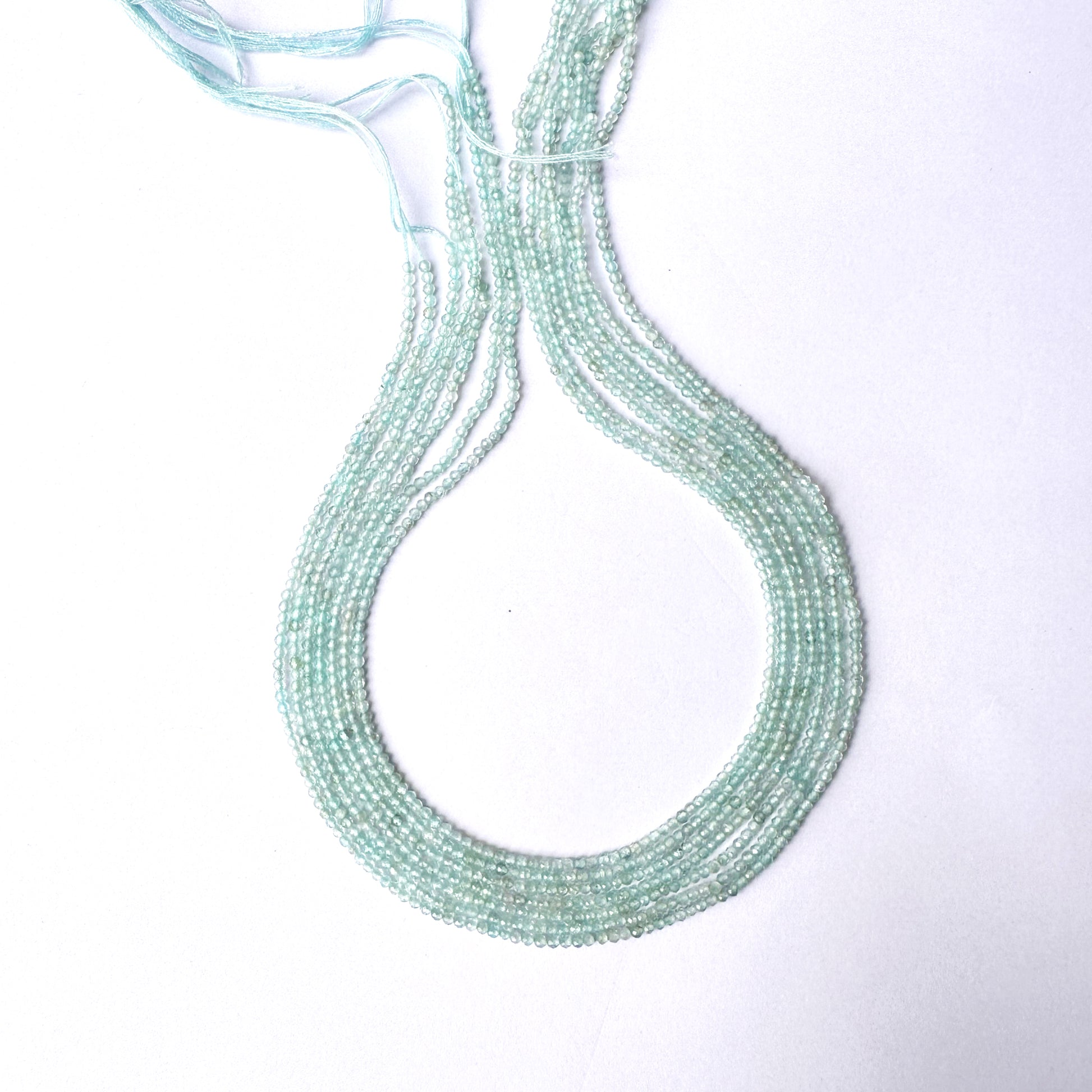 Close-up of Aquamarine gemstone beads showing delicate cuts and polished texture.