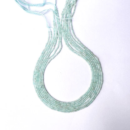Close-up of Aquamarine gemstone beads showing delicate cuts and polished texture.