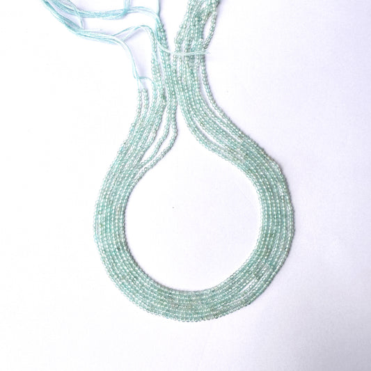 Close-up of Aquamarine gemstone beads showing delicate cuts and polished texture.