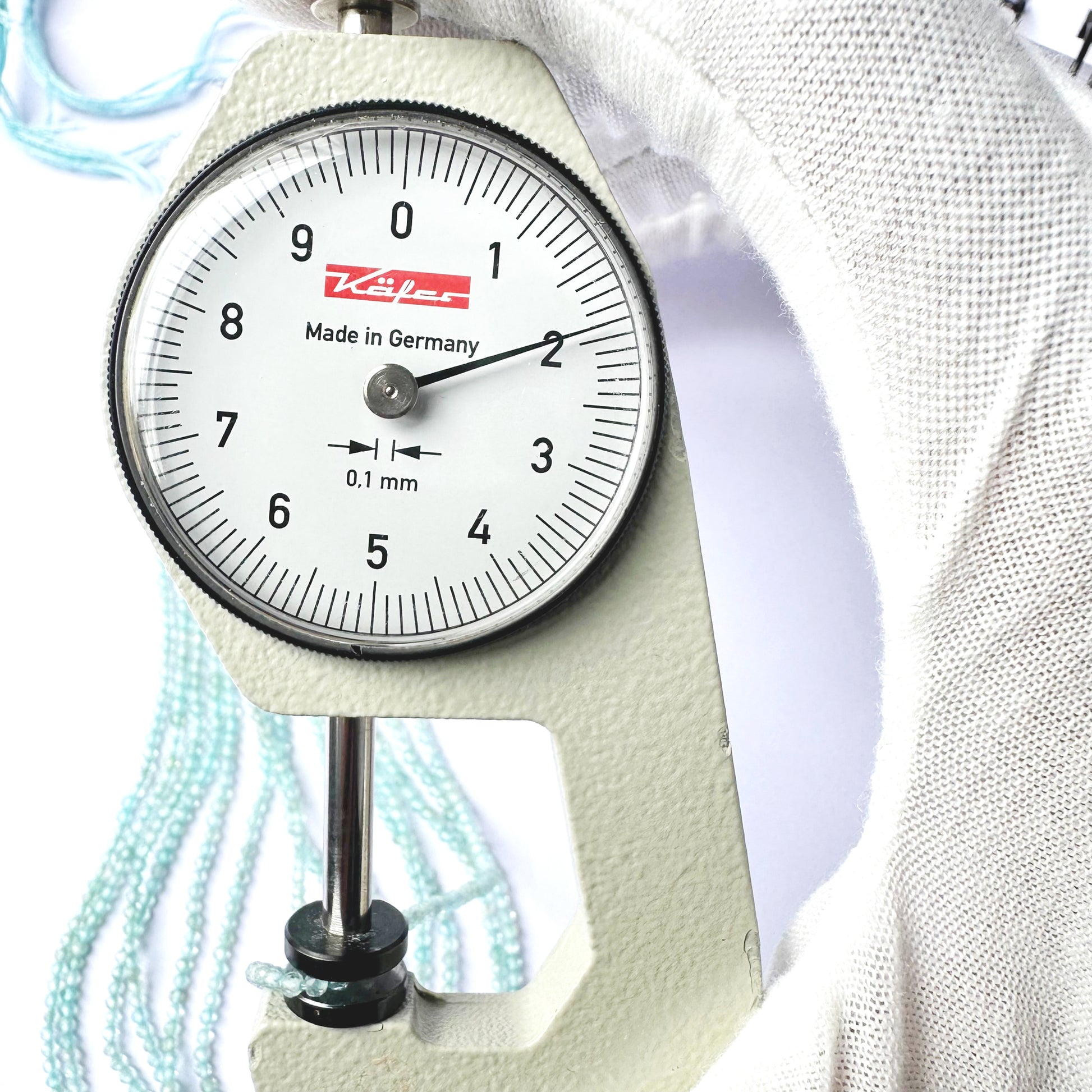 A dial gauge measures the Aquamarine faceted rondelle 2.0mm gemstone.
