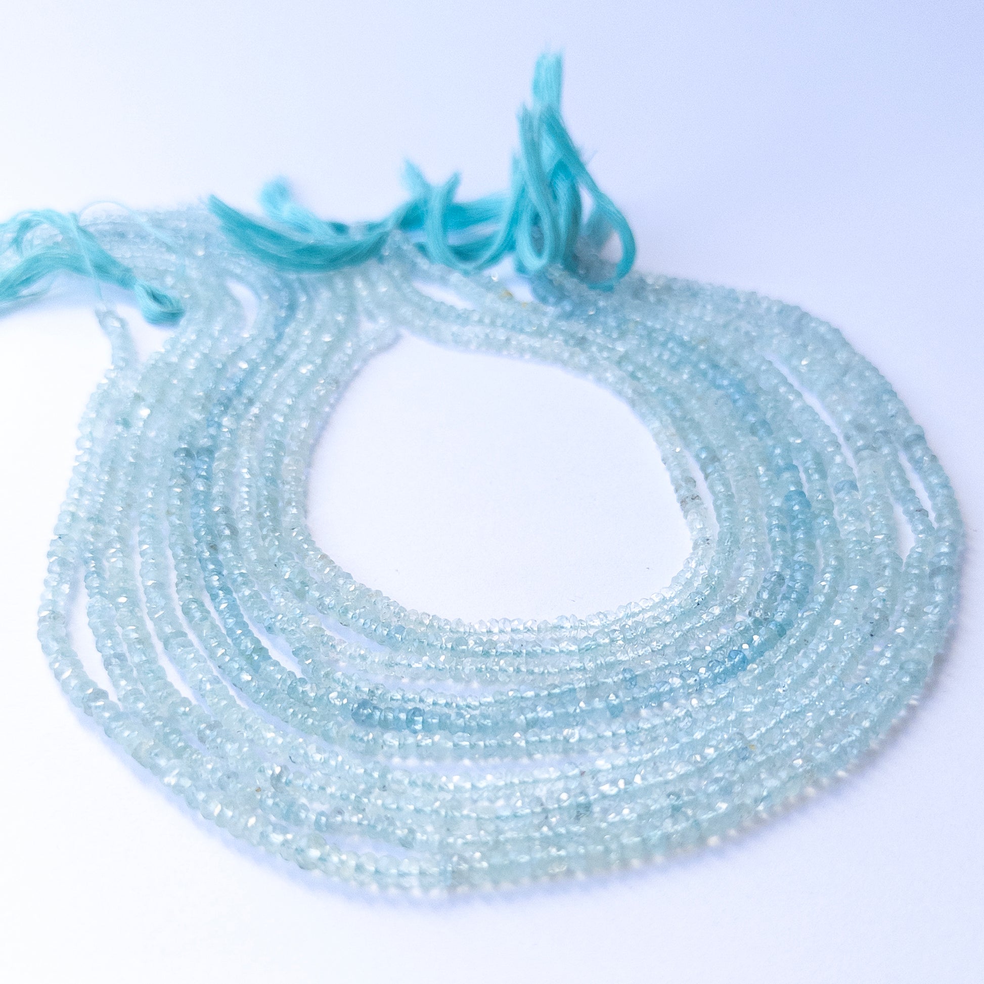 Close‑up of authentic Aquamarine faceted rondelle stone beads highlighting sparkle, clarity, and quality for DIY jewellery making.
