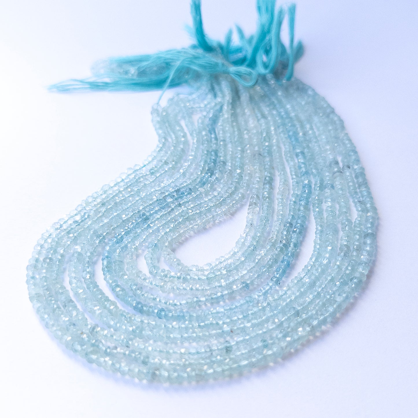 Aquamarine faceted rondelle beads with natural colour variation, perfect for handmade jewellery components and creative beadwork.