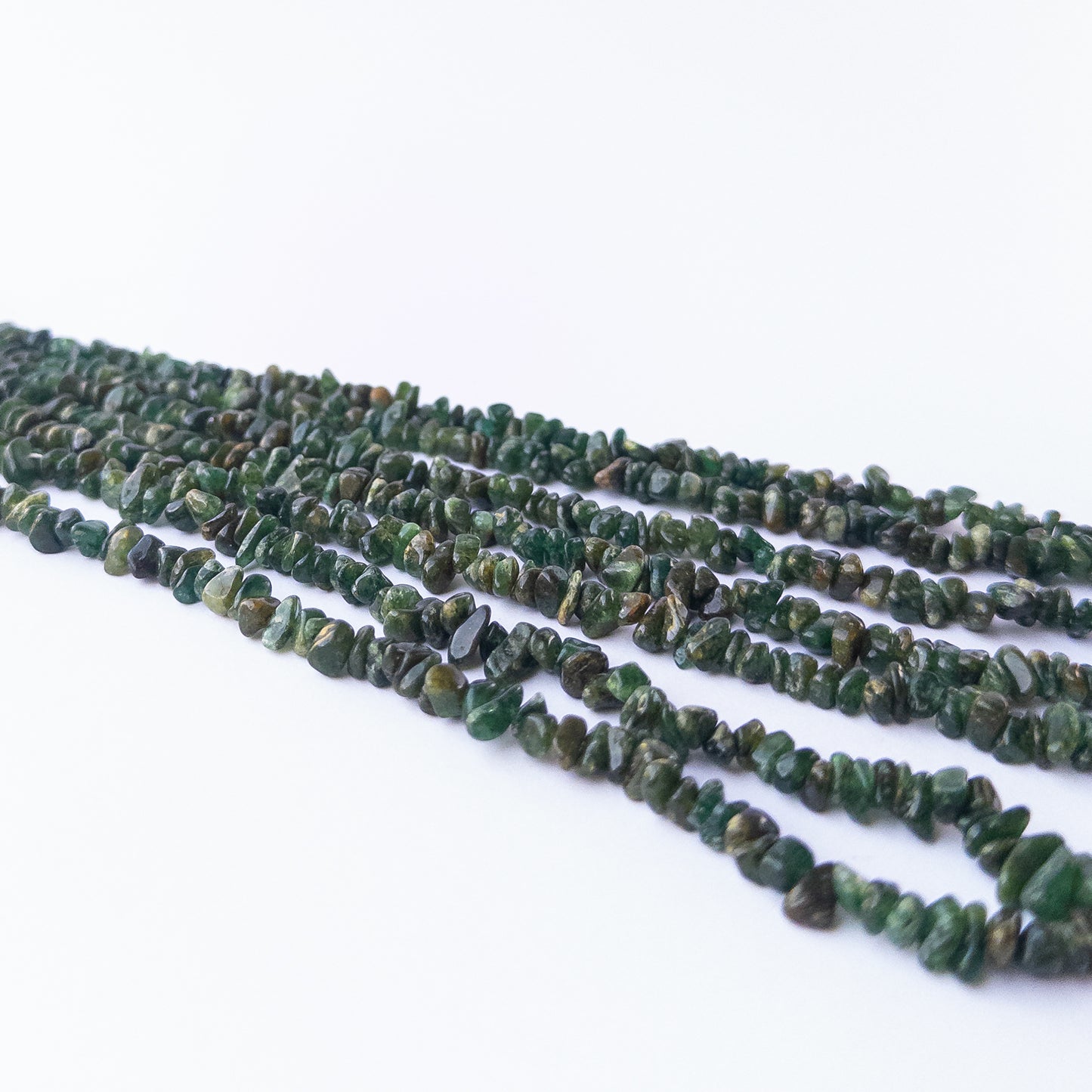 Premium Aventurine gemstone beads showcasing polished chips and nuggets with earthy green tones.