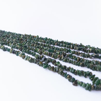 Premium Aventurine gemstone beads showcasing polished chips and nuggets with earthy green tones.