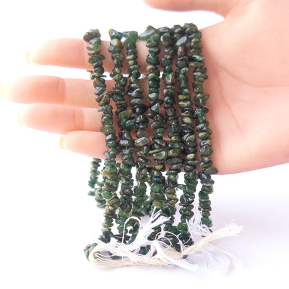 A person holds delicate strands of Aventurine beads, showcasing their chips and nuggets design.