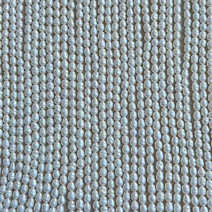 Close-up of Baroque Rice Pearls in creamy white tones with lustrous surface finish and organic rice shape.