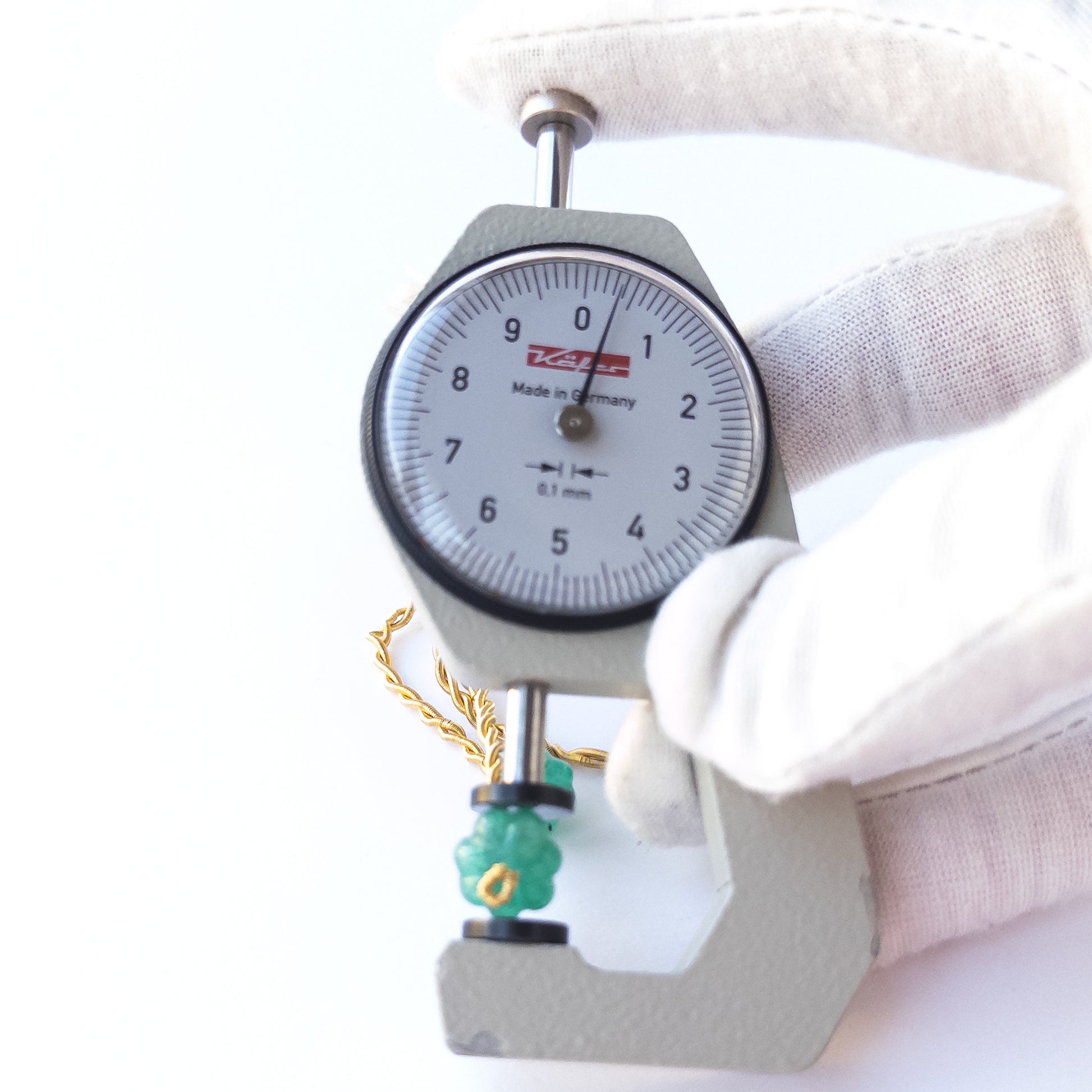 A dial gauge measures the Beryl pumpkin‑cut 9–10.5mm gemstone.