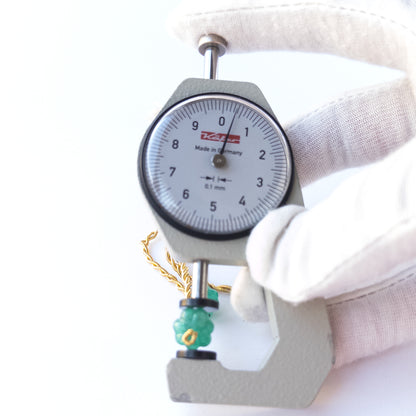 A dial gauge measures the Beryl pumpkin‑cut 9–10.5mm gemstone.