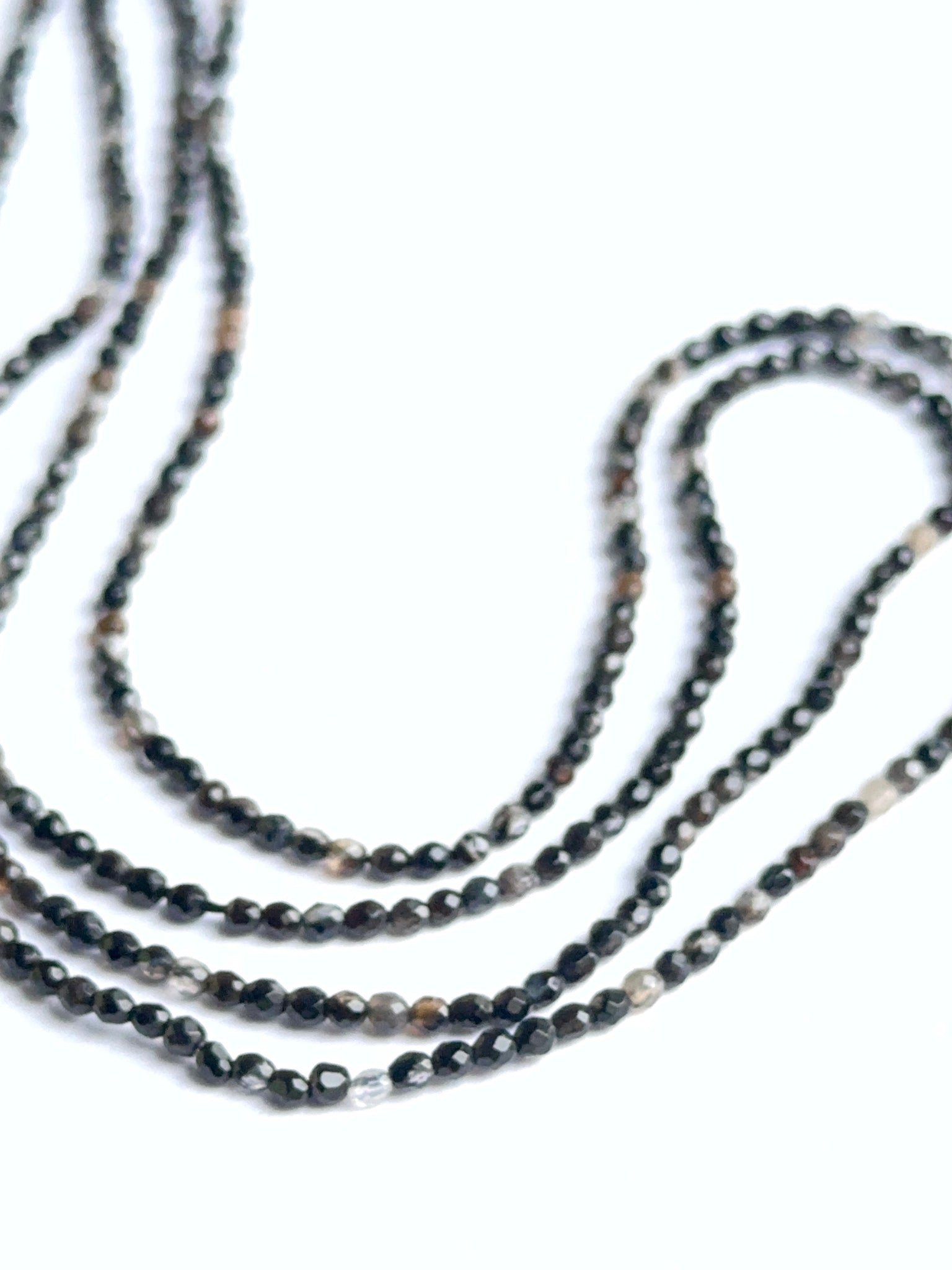 Faceted black fluorite beads displayed with reflective surfaces ideal for natural gemstone beads in jewellery making.