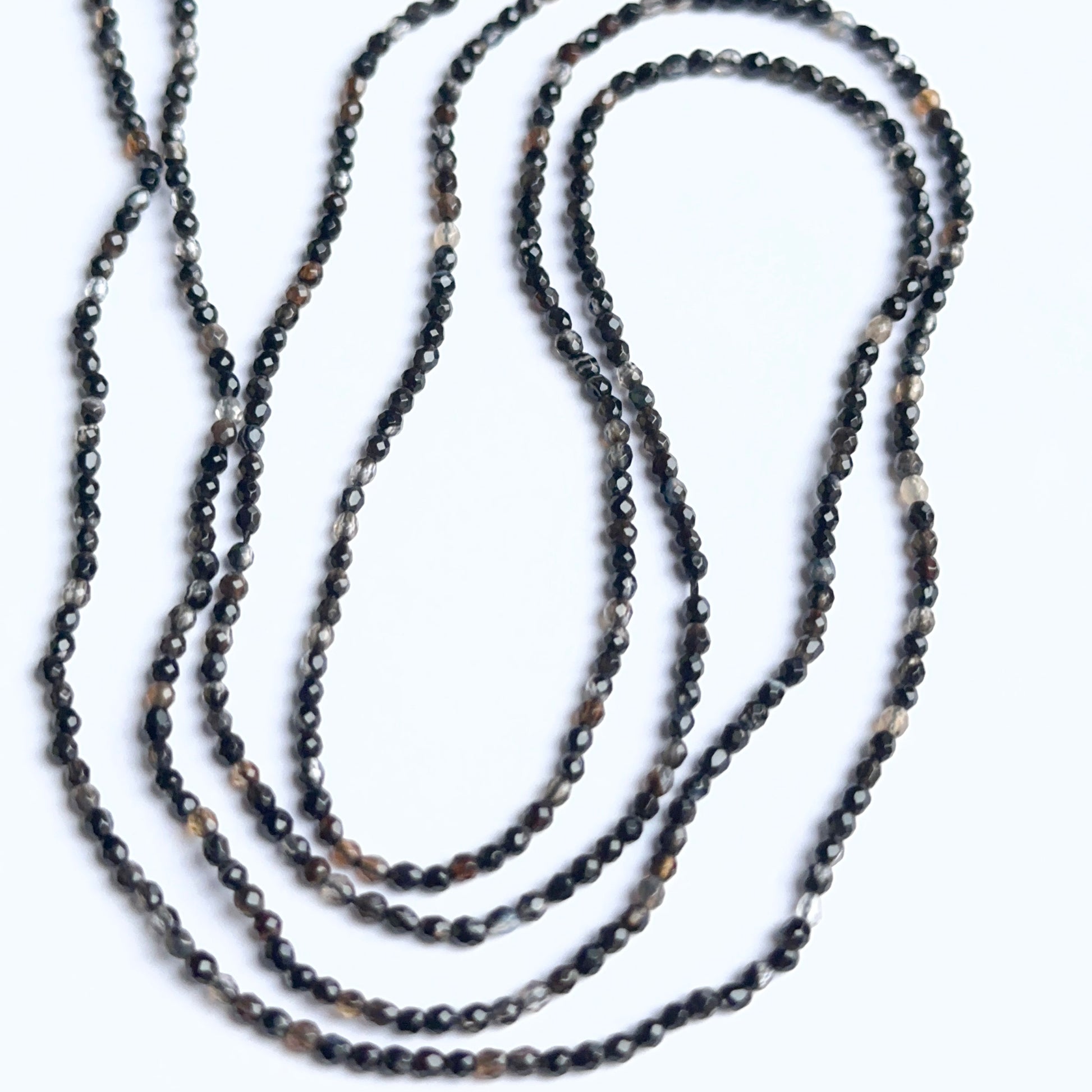 Black fluorite rondelle beads photographed to show their polished finish and suitability for handmade jewellery components.