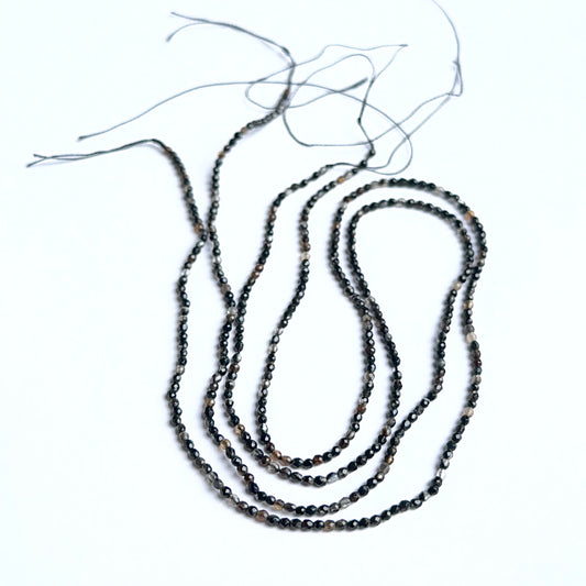 Close‑up of black fluorite stone beads highlighting their sparkle and natural gemstone quality for DIY jewellery.