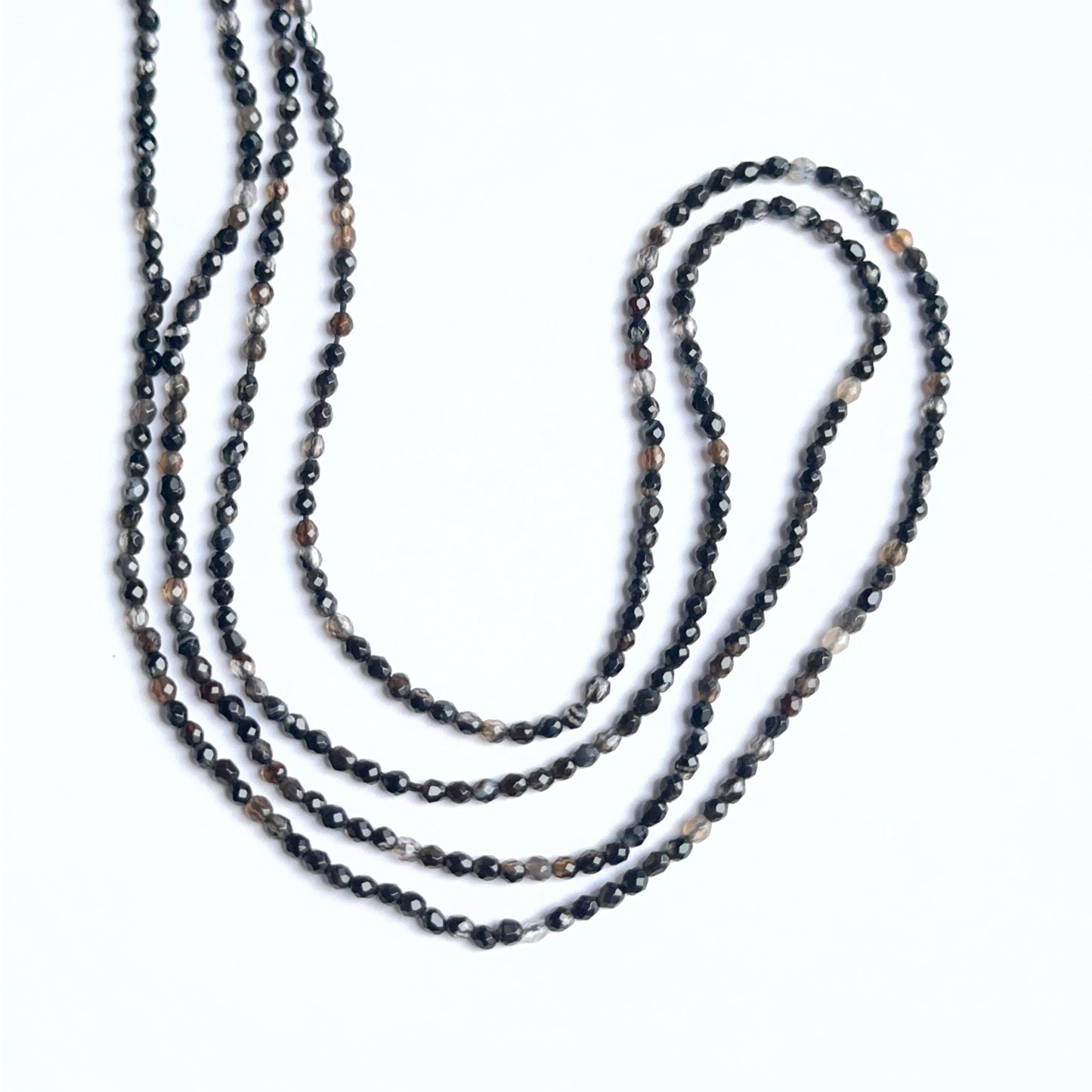 Black fluorite faceted rondelles arranged neatly to showcase shine and precision cutting.