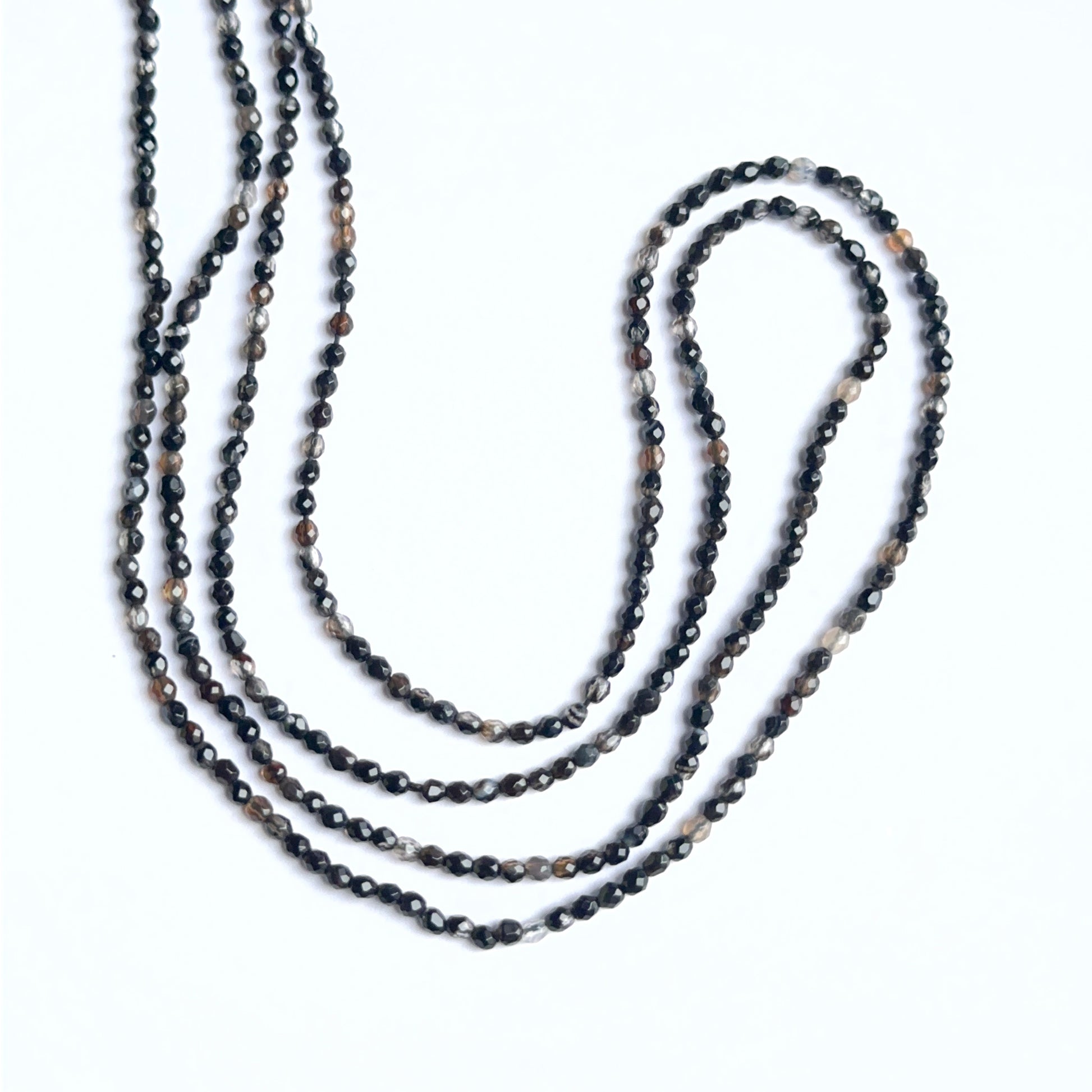 Black fluorite faceted rondelles arranged neatly to showcase shine and precision cutting.