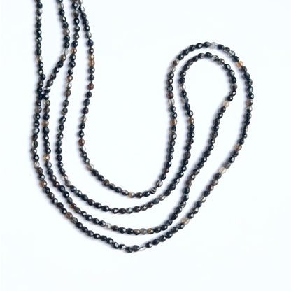 Black fluorite faceted rondelles arranged neatly to showcase shine and precision cutting.