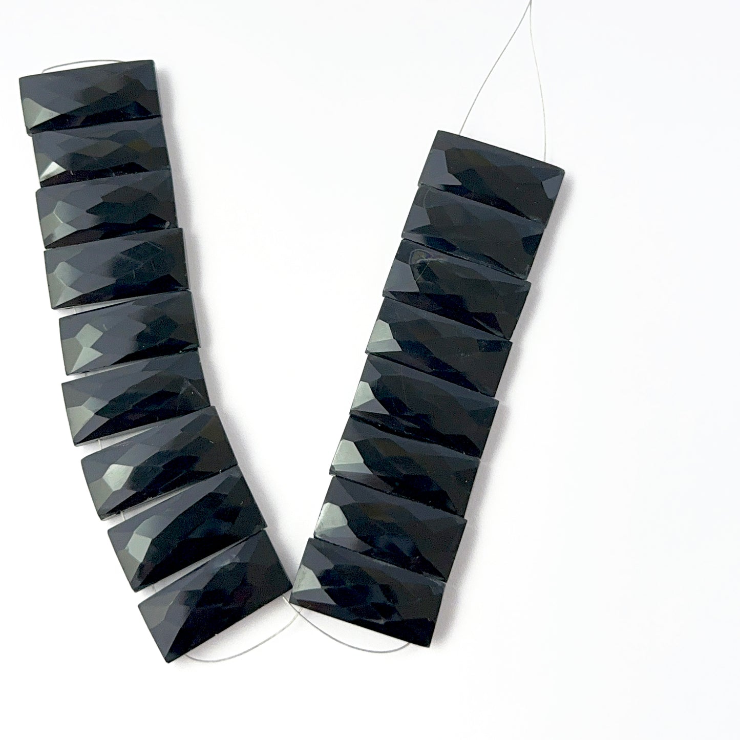 Black Onyx faceted rectangle stone beads arranged in a row, highlighting their bold colour and premium handmade jewellery component quality.