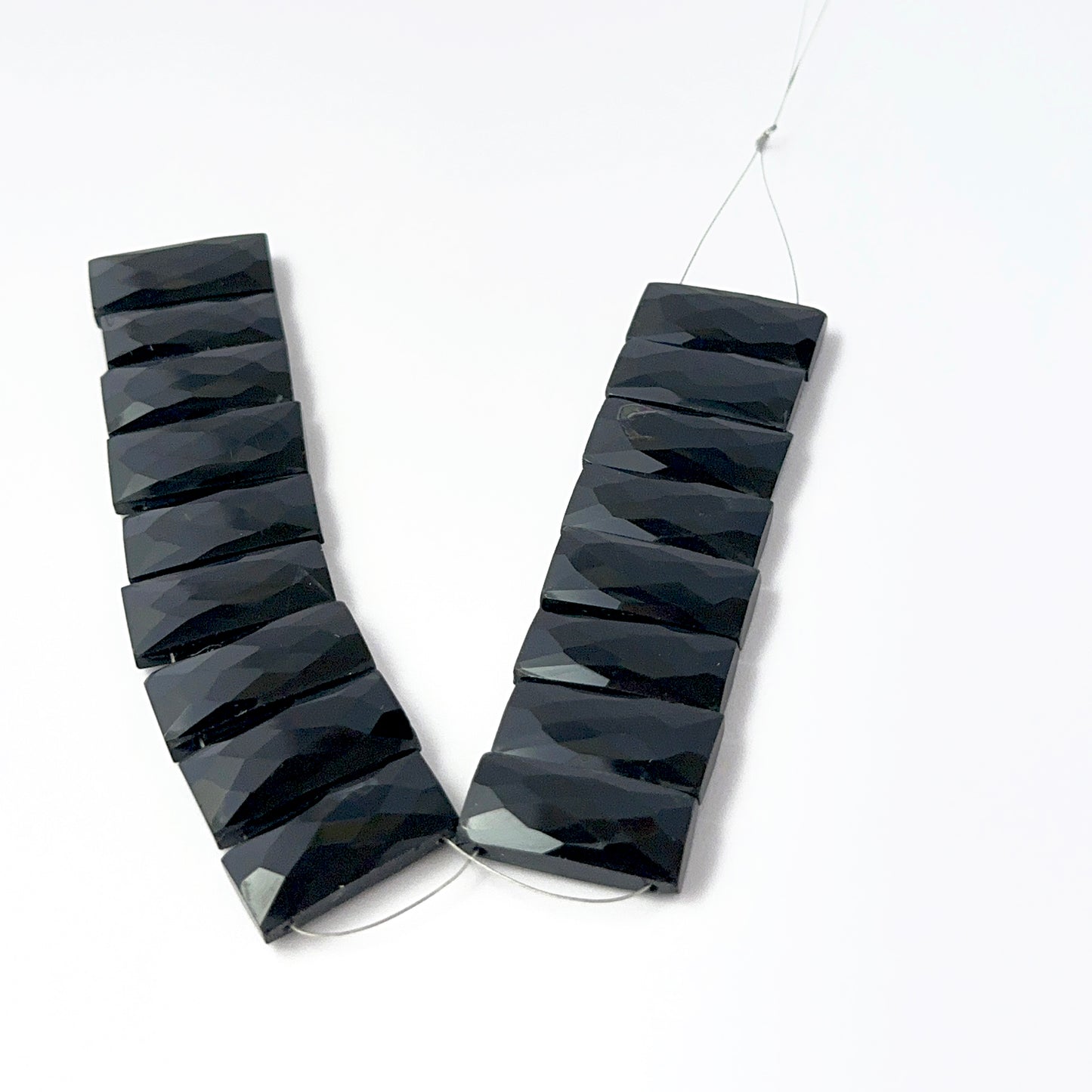 Faceted rectangle Black Onyx stone beads arranged neatly, highlighting their polished finish and handmade jewellery component quality.