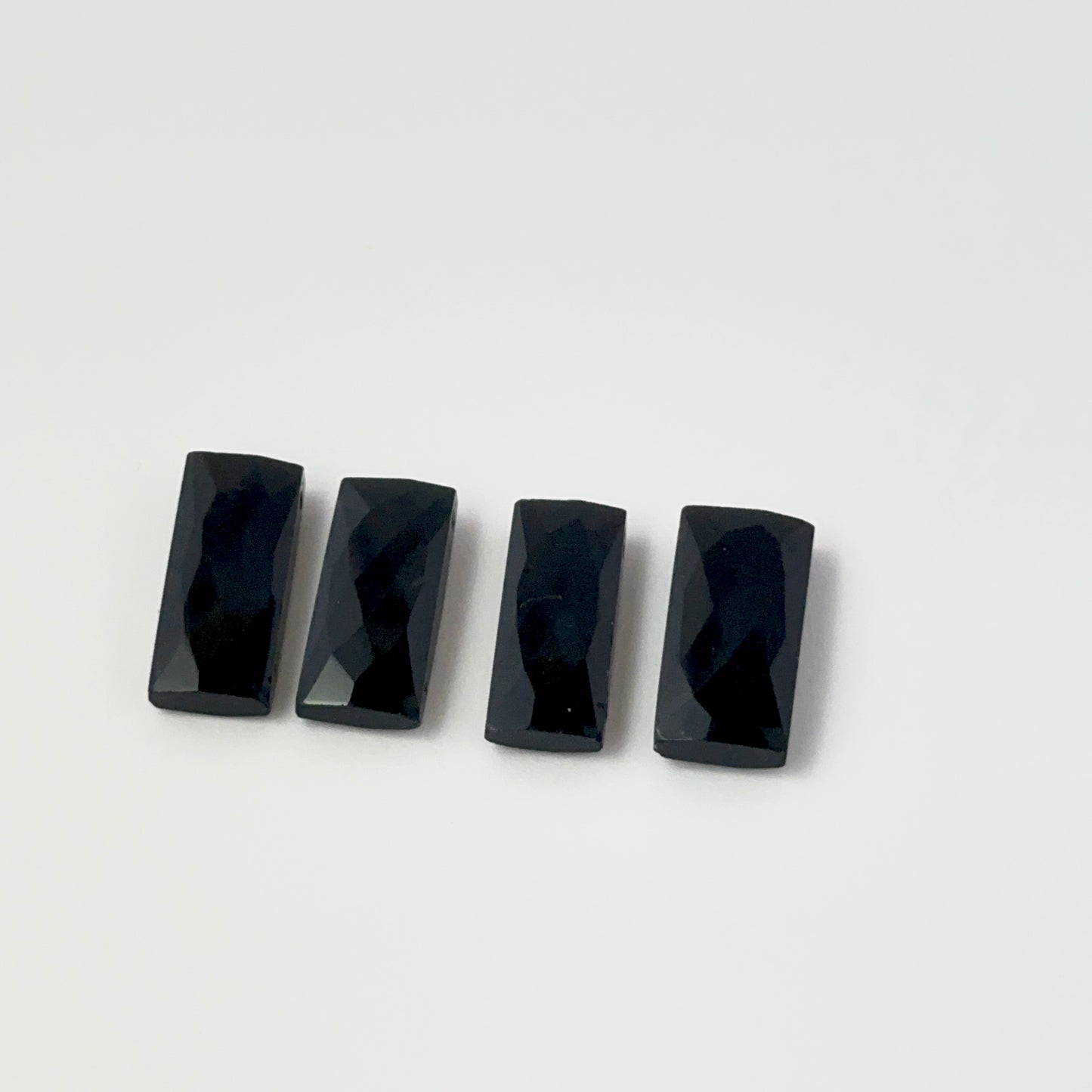 Individaal pieces of Black Onyx beads palced on a white background