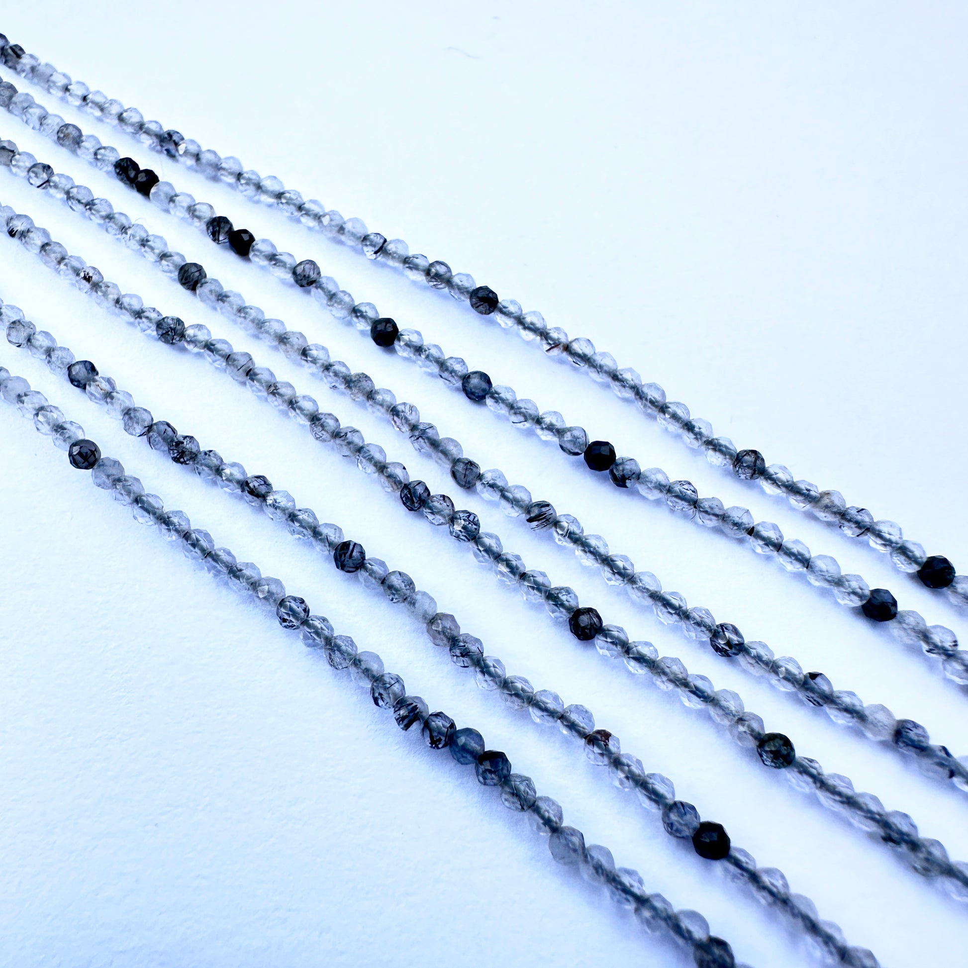 Handmade jewellery components showcasing black rutile stone beads with sparkling facets and natural gemstone quality
