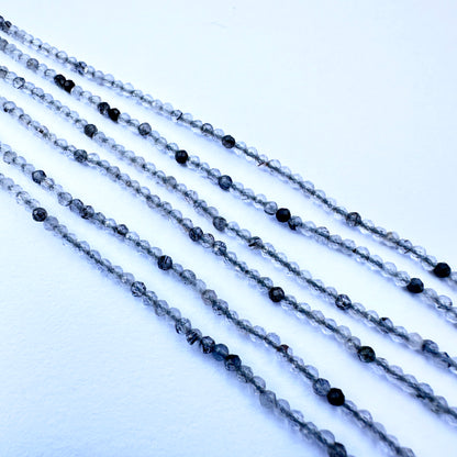 Handmade jewellery components showcasing black rutile stone beads with sparkling facets and natural gemstone quality