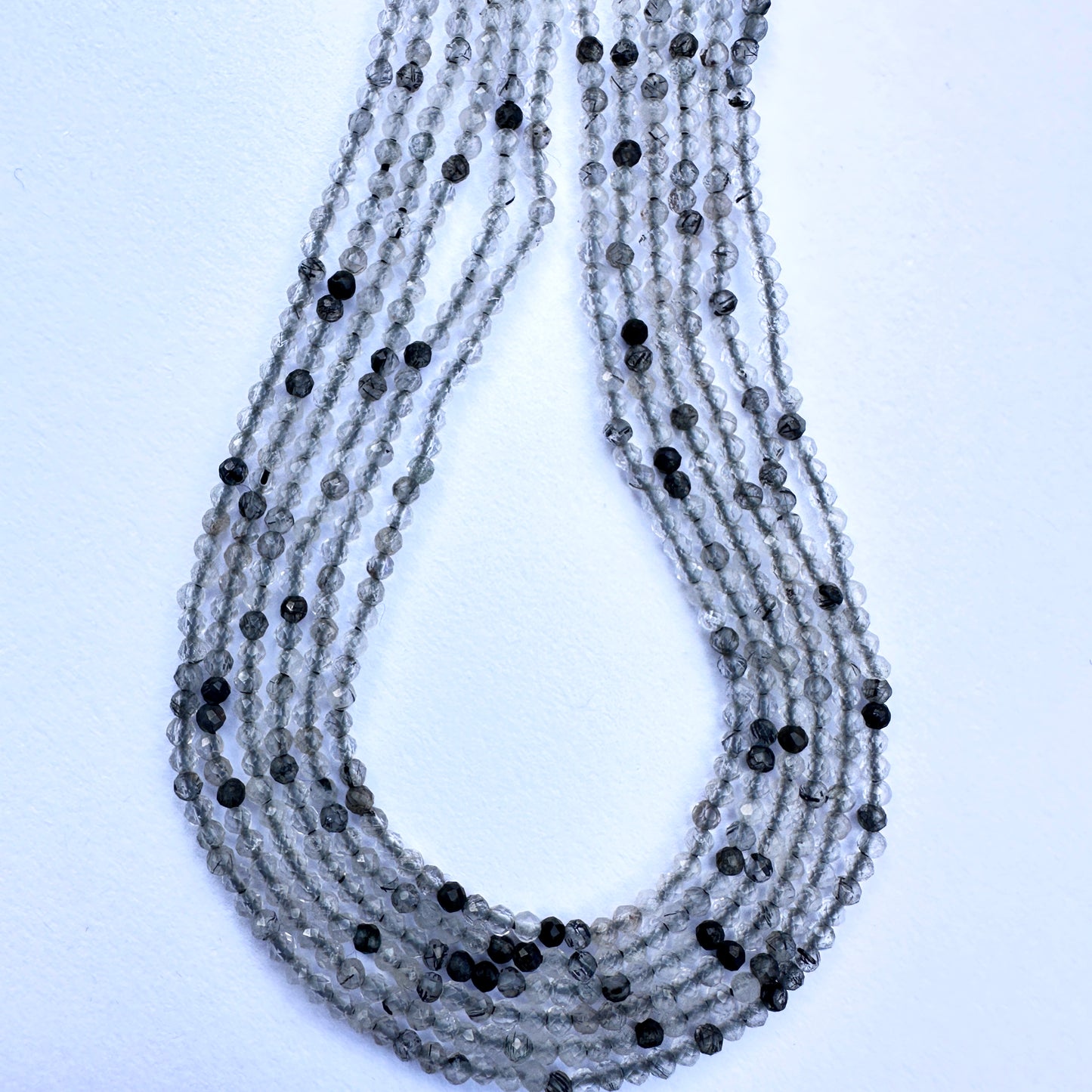 Stone beads for DIY jewellery featuring micro faceted rondelle cut and subtle dark inclusions for unique texture