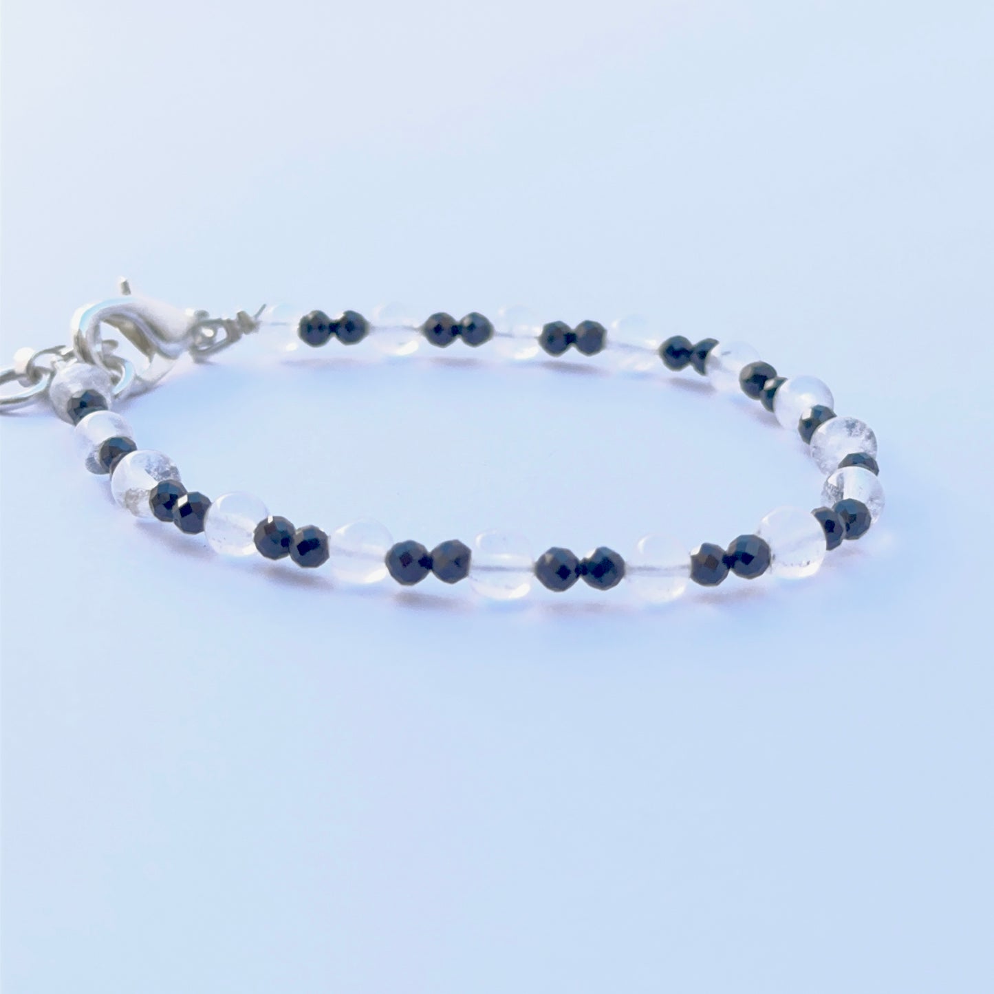 Black spinel and crystal bracelet arranged neatly to showcase natural gemstone quality and smooth bead shape.