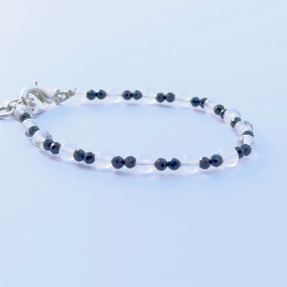 Black spinel and crystal bracelet arranged neatly to showcase natural gemstone quality and smooth bead shape.