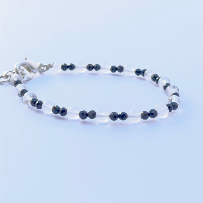Black spinel and crystal bracelet arranged neatly to showcase natural gemstone quality and smooth bead shape.