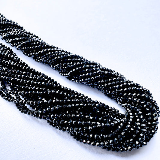 Black Spinel faceted rondelle beads with deep black sparkle arranged on a 32cm strand for jewellery making.