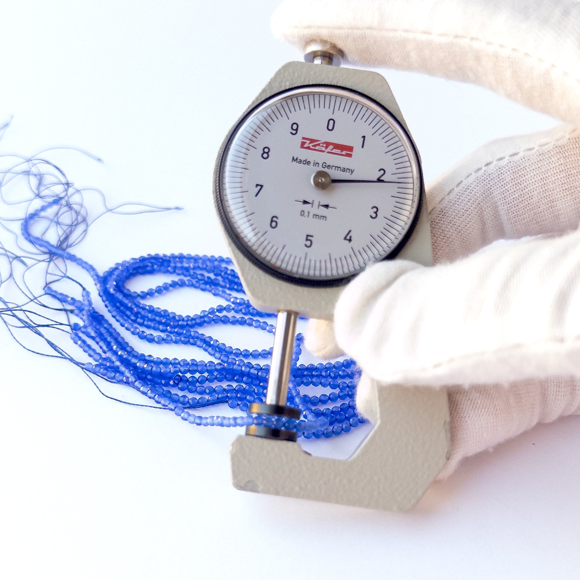 A dial gauge measures the Blue Chalcedony faceted rondelle 2.1mm gemstone.